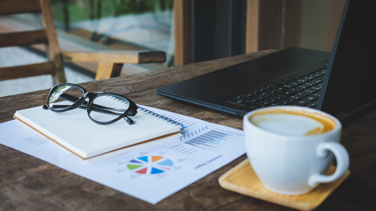 Website Development Table Setup With Laptop Charts And Coffee